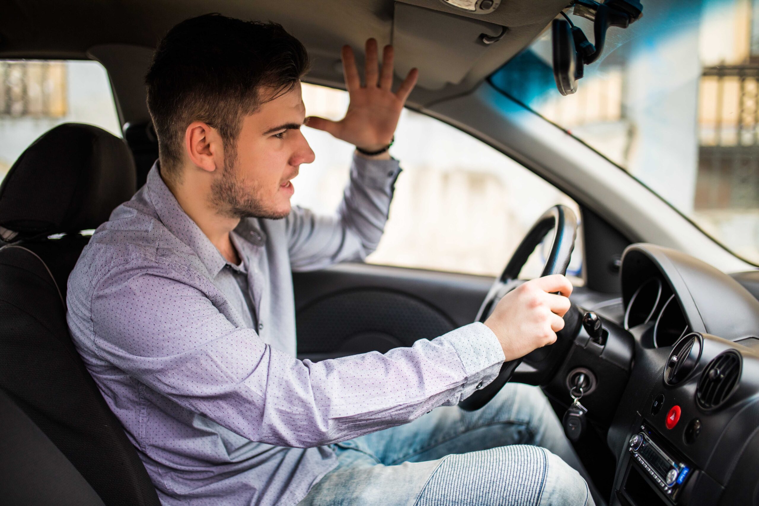 Side view of angry man in casual wear driving car